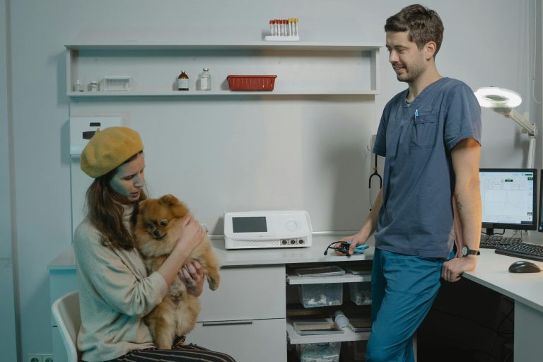 A veterinarian in a clinic consulting with a pet owner and her Pomeranian dog.